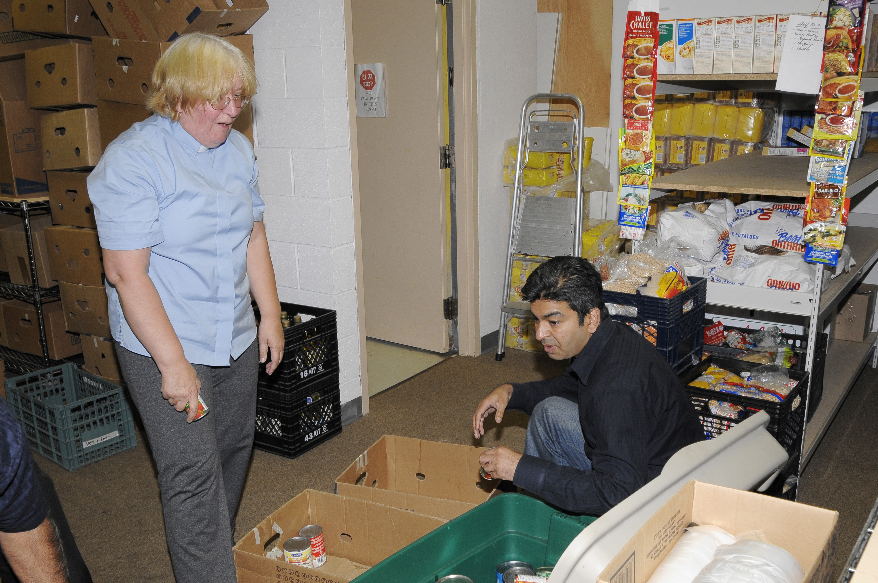 Ismaili volunteer Nazmal Kanji together with Rev Helena-Rose Houldcroft, Director of the Flemingdon Park Ministry, working to sort and shelve donated food at the Flemingdon food bank. Photo: Moez Visram