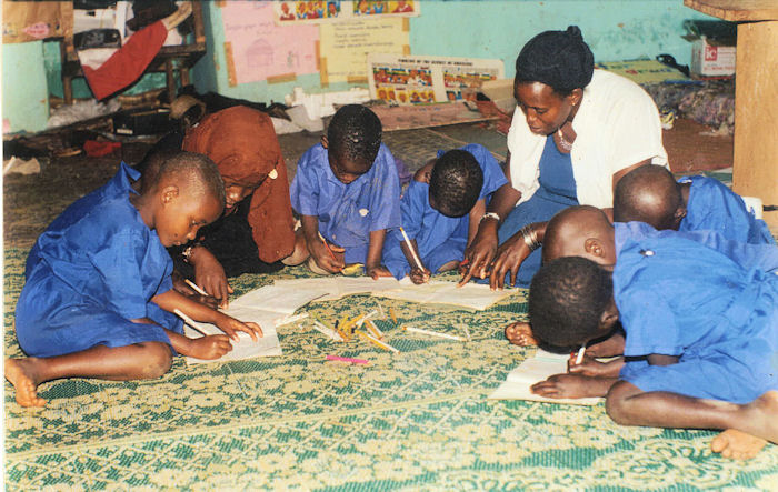 Madrasa school students concentrate as their teacher helps them to write sentences in English. Photo: Courtesy of Shamim Murji