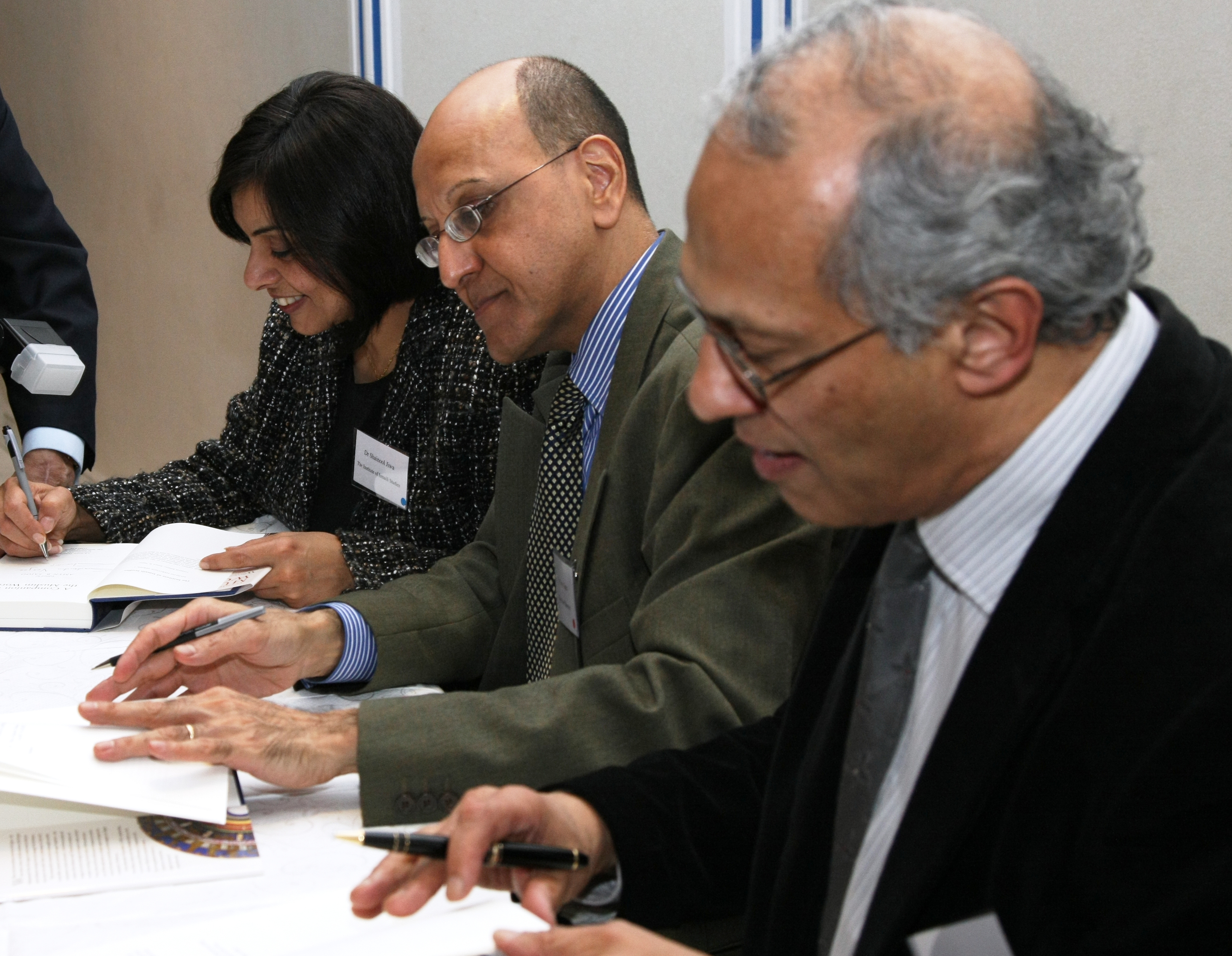 Contributors to “A Companion to the Muslim World” – Dr Shainool Jiwa, Dr Amyn B. Sajoo and Raficq Abdulla – sign books for guests. Photo: Courtesy of The Institute of Ismaili Studies