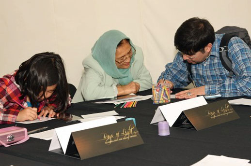 Jamati members from Europe write their impressions of the RAYS OF LIGHT exhibition on comment cards. Photo: Alnoor Sunderji