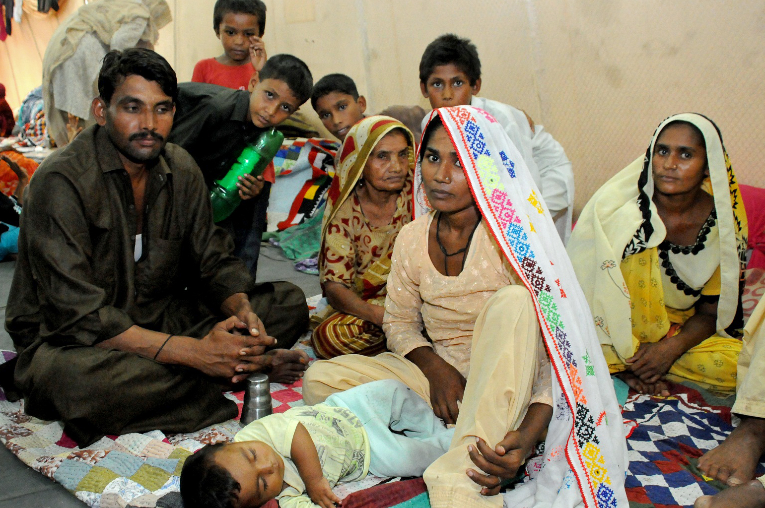 A family finds shelter from the flood devastation at a FOCUS relief camp in Sindh. Photo: Ismaili Council for Pakistan / Al Jaleel