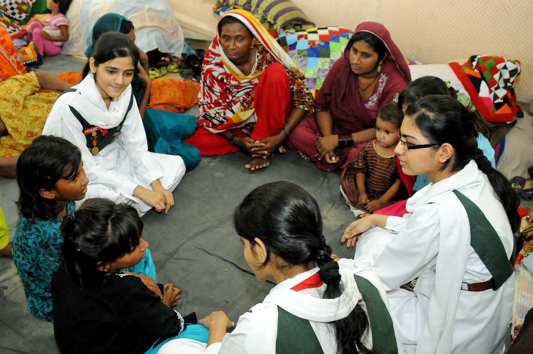 Ismaili Girl Guides spend time playing with the children at a relief camp in Hyderabad. Photo: Ismaili Council for Pakistan / Al Jaleel