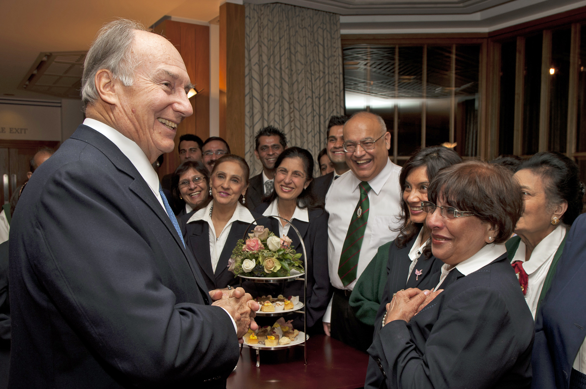 Mawlana Hazar Imam stops to speak with volunteers at a tea party for Prince Charles’ visit commemorating the 25th anniversary of the Ismaili Centre, London. Photo: Nadia Bettega