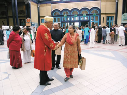 A senior Jamati leader, in ceremonial regalia, welcoming Jamati members in London. Photo: Ismaili Council for the United Kingdom 