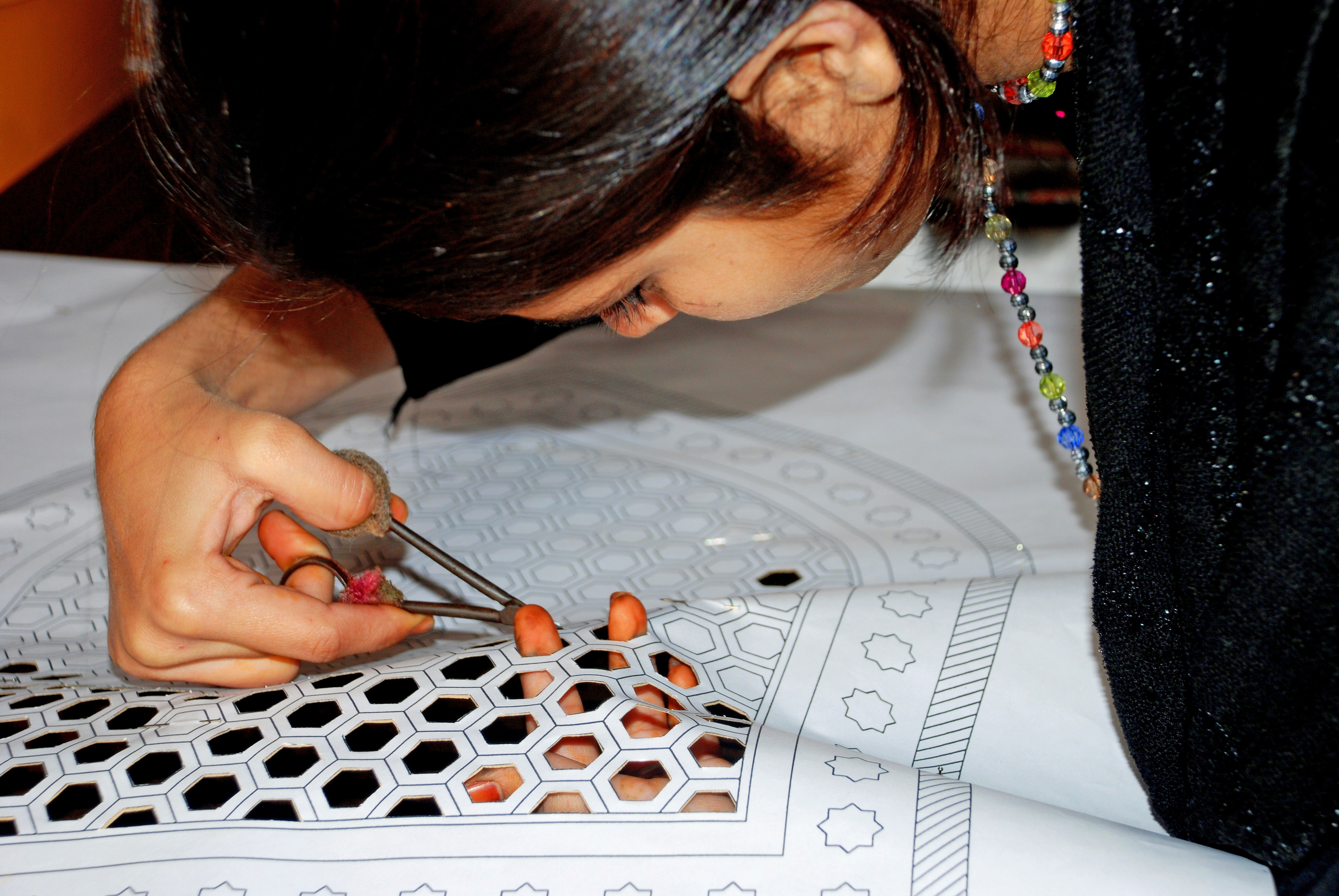 A young girl from Nizamuddin Basti cuts sanjhi patterns. Raising awareness among residents about the rich cultural heritage of the neighbourhood they live in is part of the conservation effort. Photo: Courtesy of AKTC