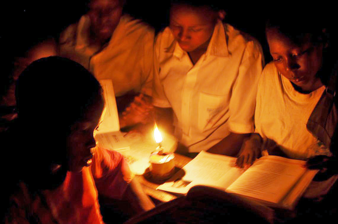 In the absence of electricity, students in a primary school classroom have to study using kerosene lamps. Photo: Courtesy of Naeem Mawji