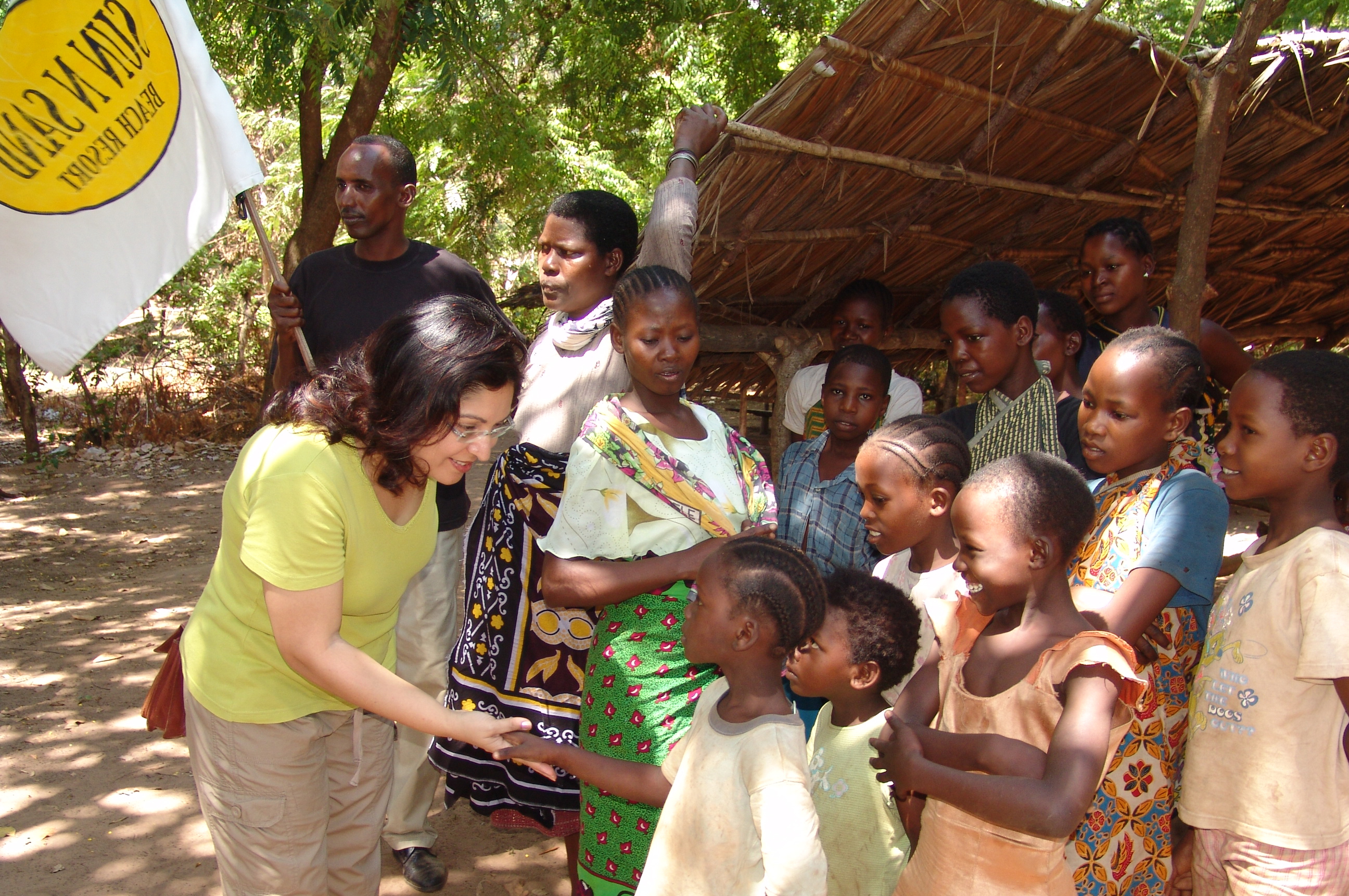 Shahinoor M. Visram, Managing Trustee of the Sun n Sand Trust, greets children in the village of Kikambala, Kenya where the Visram family has made important contributions to combating human trafficking and improving quality of life in the local community. Photo: Courtesy of Shahinoor M. Visram