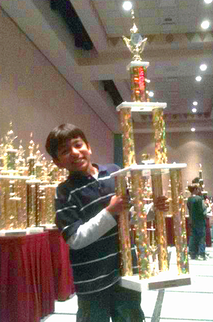 Danial Asaria celebrates with with his trophy at the US National K12 Championships. Photo: Courtesy of the Asaria Family