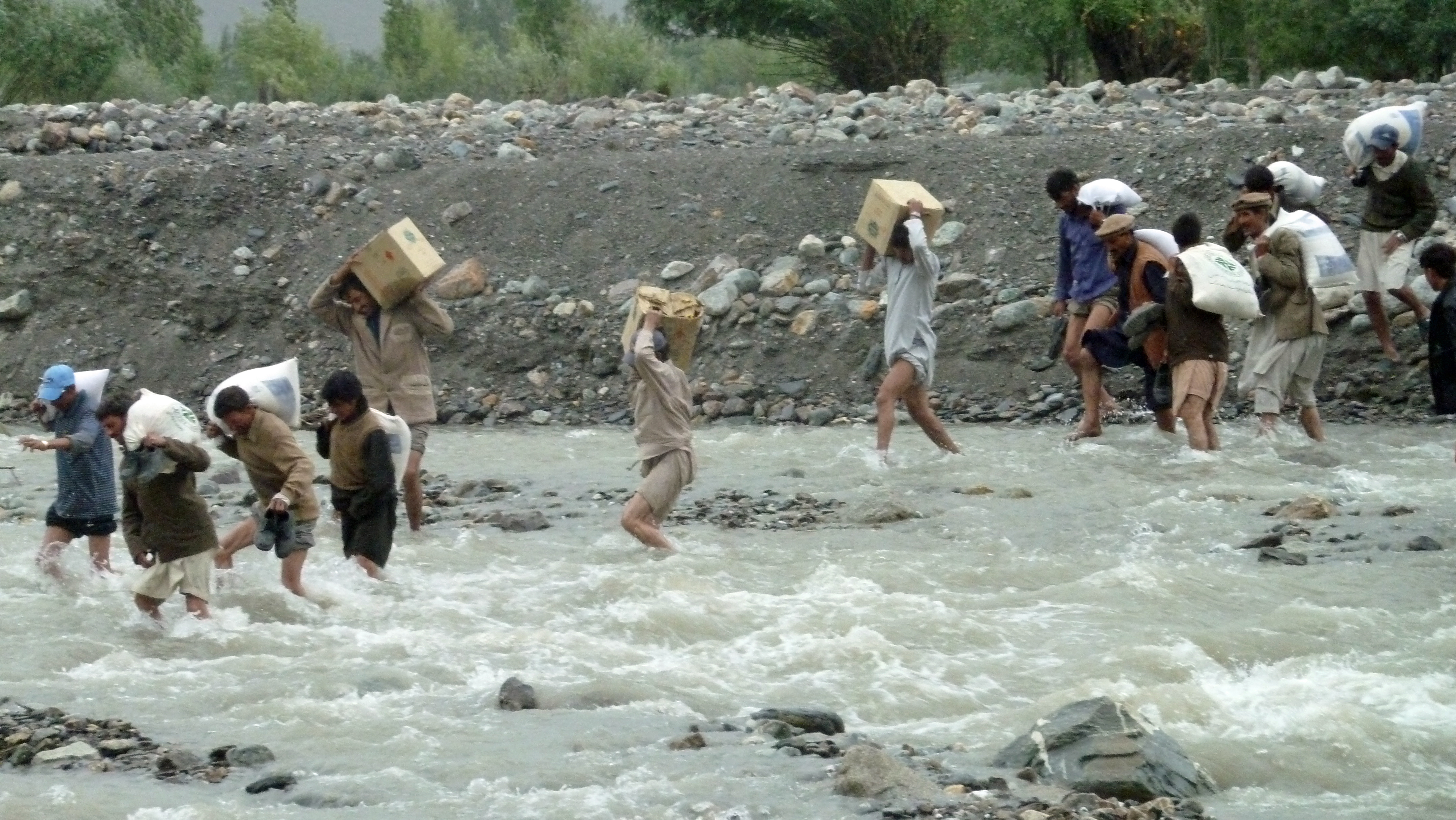 Local volunteers are seen crossing the raging river to make relief goods available to the flood affected communities in Darkut. Photo: Courtesy of the Ismaili Council for Pakistan