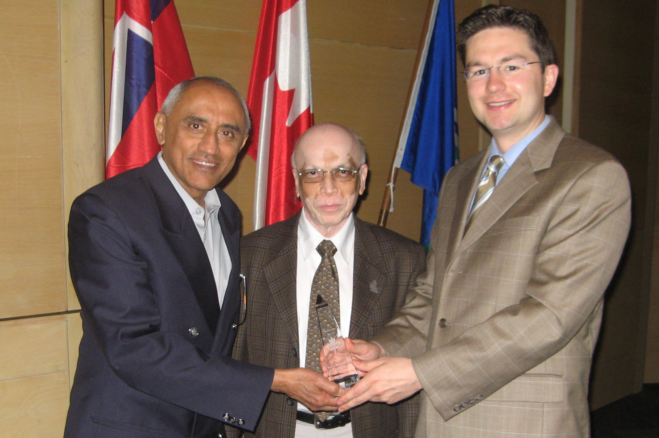 Noordin  Madatali (left) receives the MSMF Humanitarian Award from Dr Chandrasekhar Sankurathri, Founder of MSMF and Canadian Member of Parliament Pierre Poilievre. Photo: Courtesy of Noordin Madatali