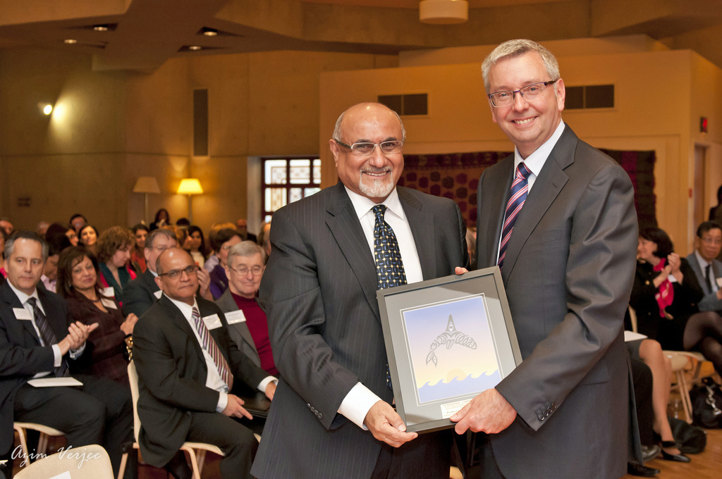 Ismaili Council for Canada President Mohammed Manji presents UBC President Stephen J. Toope with a gift — the Bismillah Whale by Sherazad Jamal. Photo: Azim Verjee