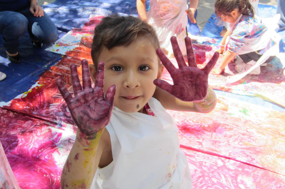 Reina, aged three-and-a-half, enjoys finger painting a mural at the Dallas ECDC Week of the Young Child in April 2012. Photo: Courtesy of The Ismaili USA