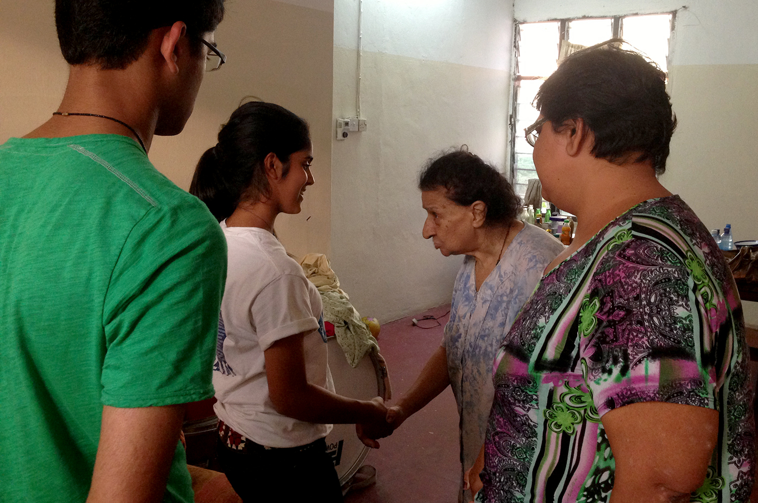 Elderly Ismaili residents at Makupa Flats welcome participants from Global Encounters into their home. Photo: Rahim Sajan