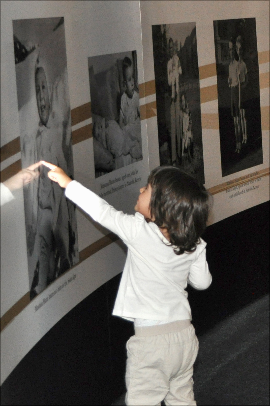 A young visitor delights in a photograph of Mawlana Hazar Imam as a baby. Photo: Courtesy of the RAYS OF LIGHT team