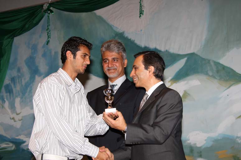 Ikhwan Allani receiving a trophy for academic excellence from Uganda from Mahmood Ahmed, AKDN Resident Representative, Uganda and Niaz Hirani, Chairman of Aga Khan Education Services. Photo: Zahir Rehemtulla.